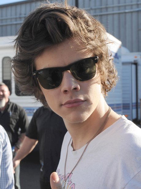 Phwoar! Harry give fans a flash of his famous locks in some sunglasses